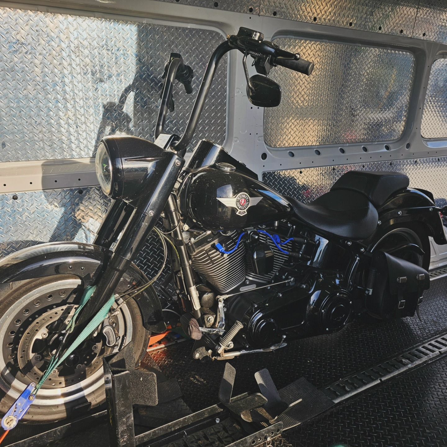 A black motorbike is tied down in back of truck while being transported— Motow Motorcycle Transport In Sandgate, NSW