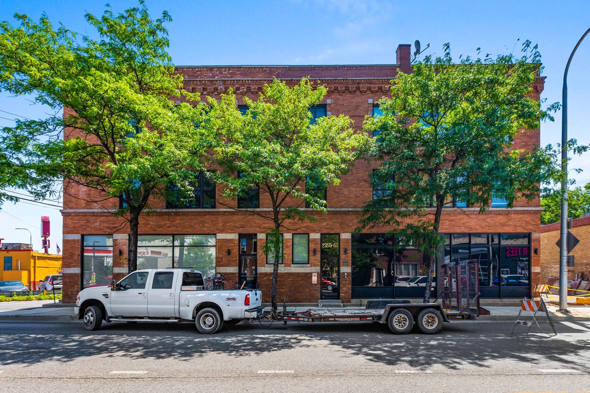 A white truck is parked in front of a brick building.
