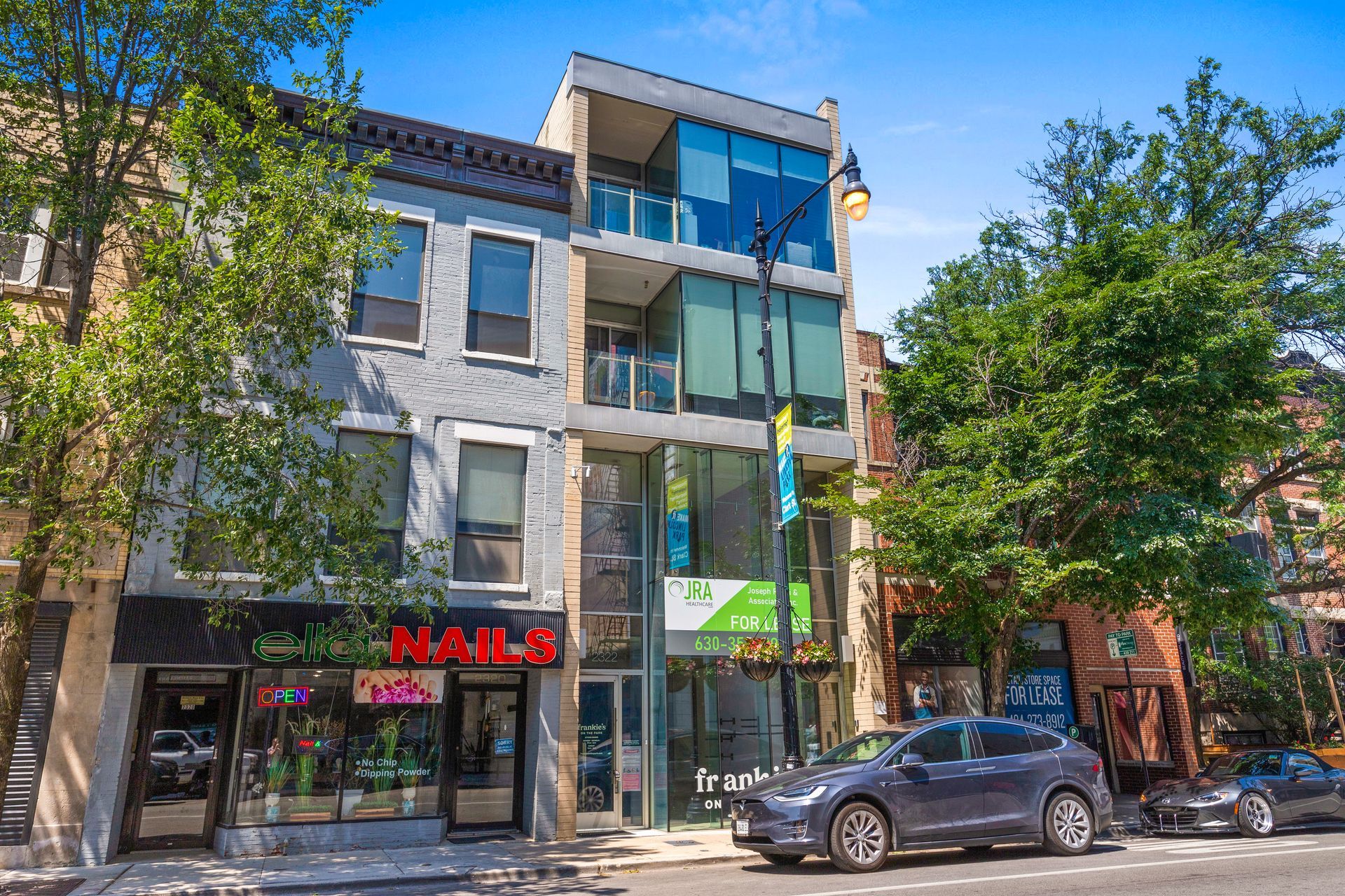 A car is parked in front of a building on a city street.