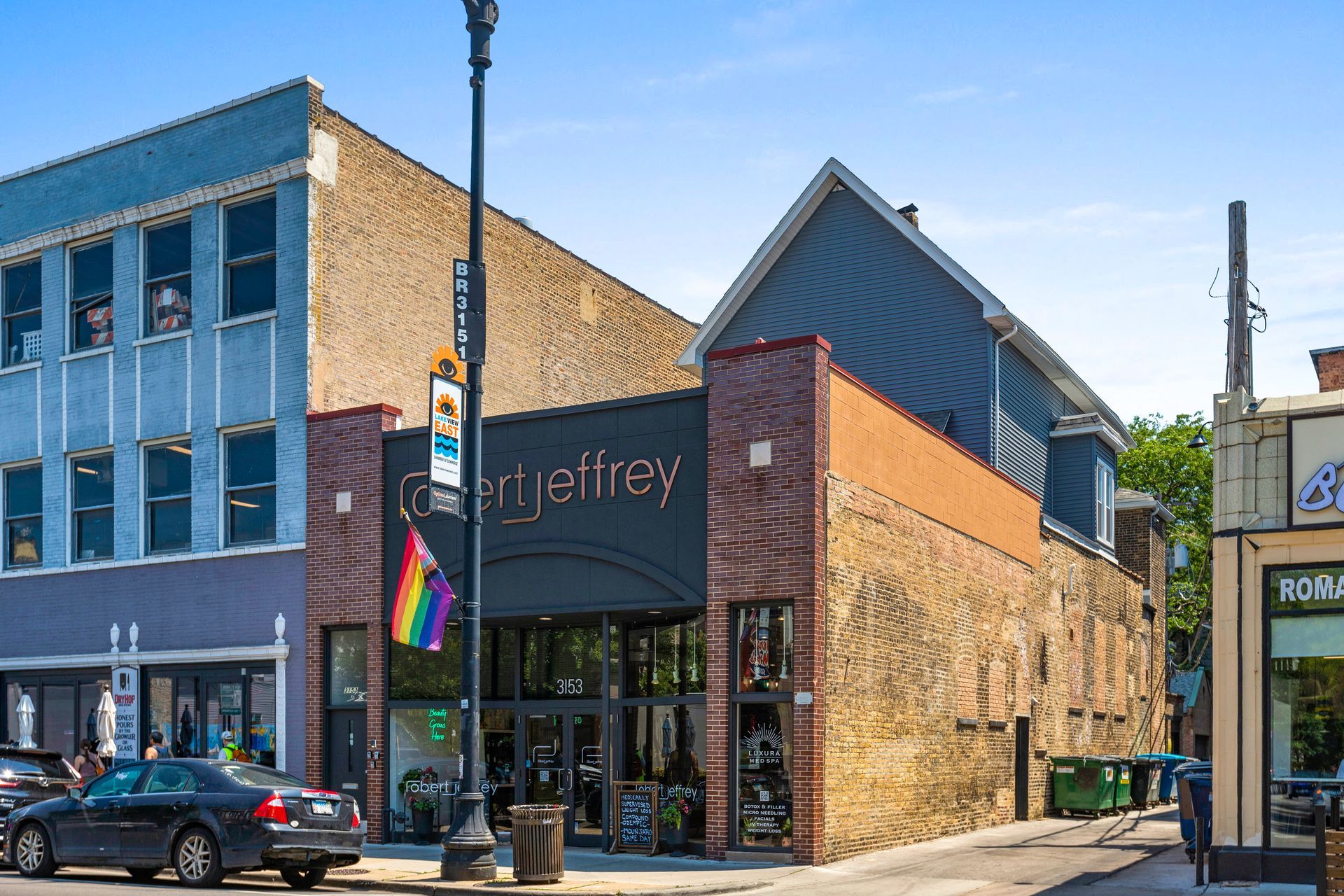 A car is parked in front of a building that says george frey