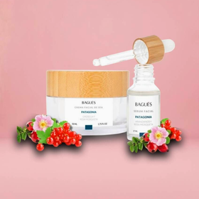 Frascos y tarros de productos para el cuidado de la piel de color rosa con flores sobre un fondo rosa pastel.
