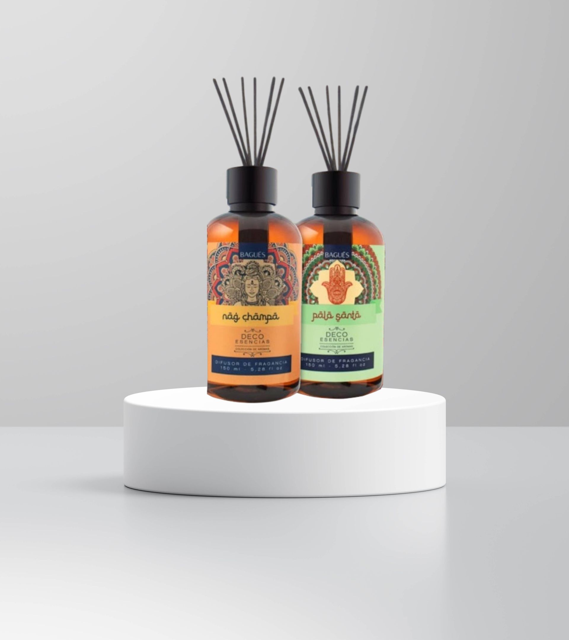 Dos frascos difusores de color ámbar con varillas sobre un pedestal blanco, uno con etiqueta naranja.