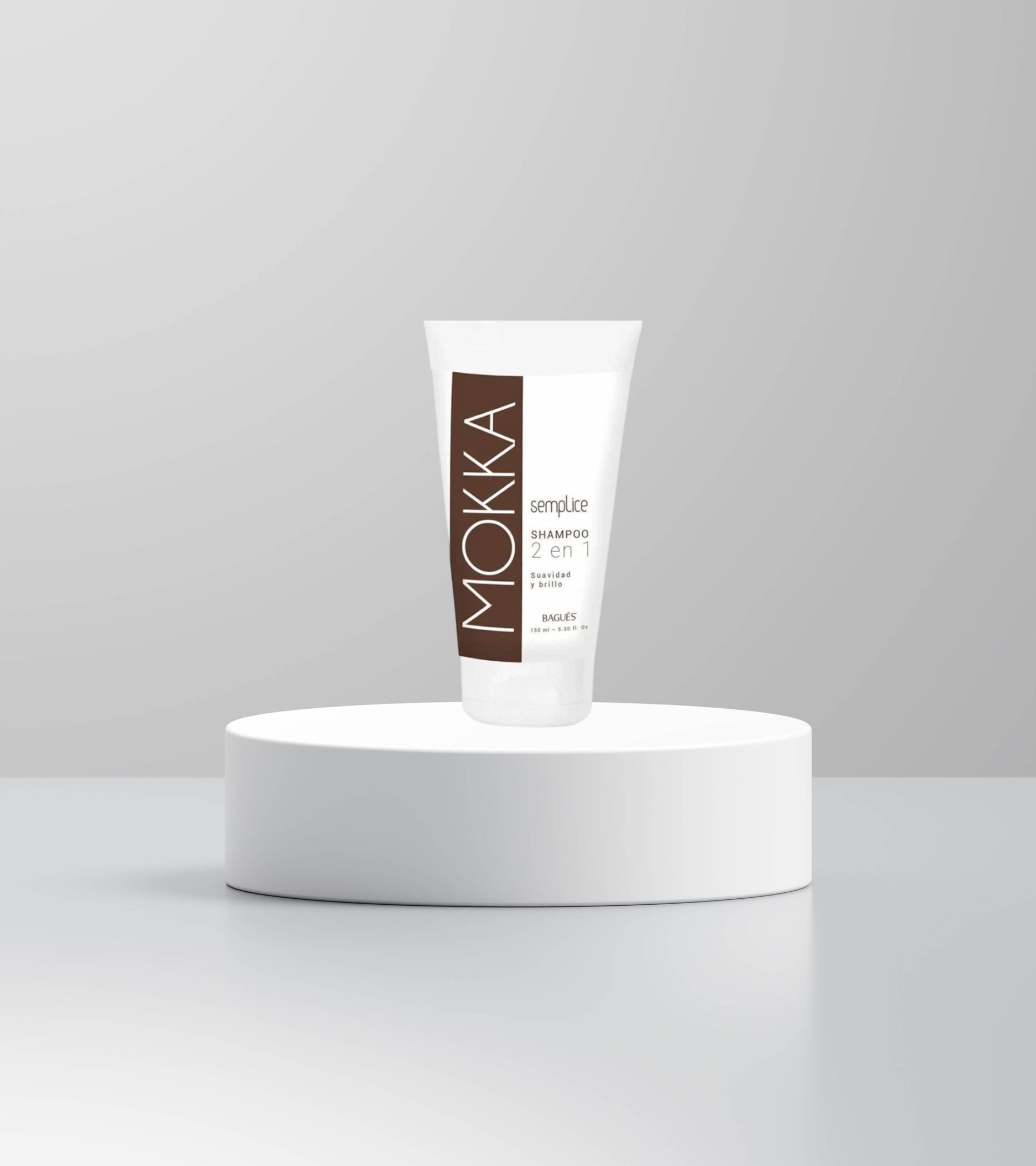 Tubo cosmético blanco con etiqueta marrón sobre un pedestal blanco sobre un fondo gris.