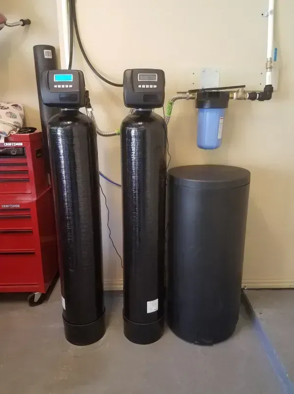 Water filtration system: Two tall black tanks with digital displays, a blue filter, and a round black tank.