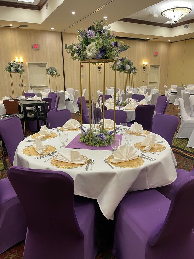 A large room with tables and chairs set up for a wedding reception.