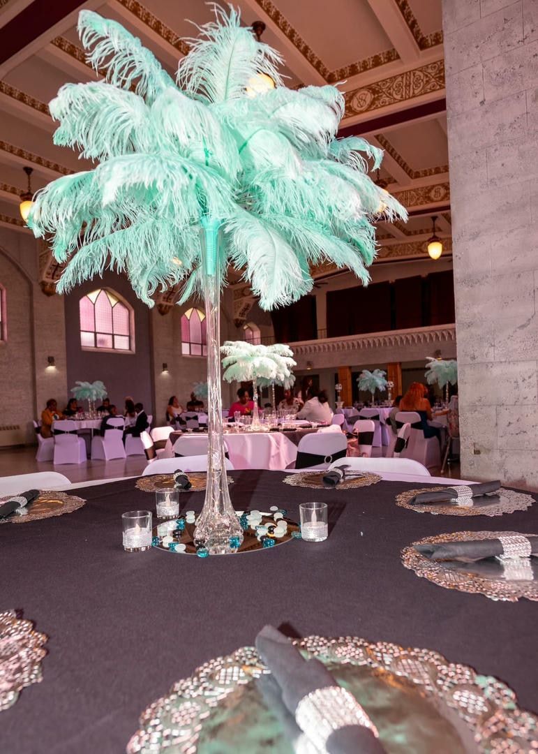 A table with feathers on it and candles on it