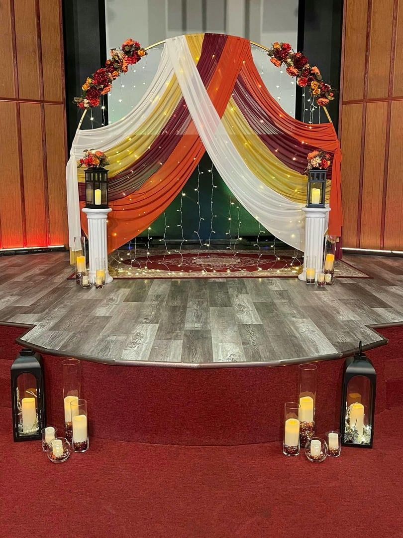 There is a stage with candles and flowers on it.