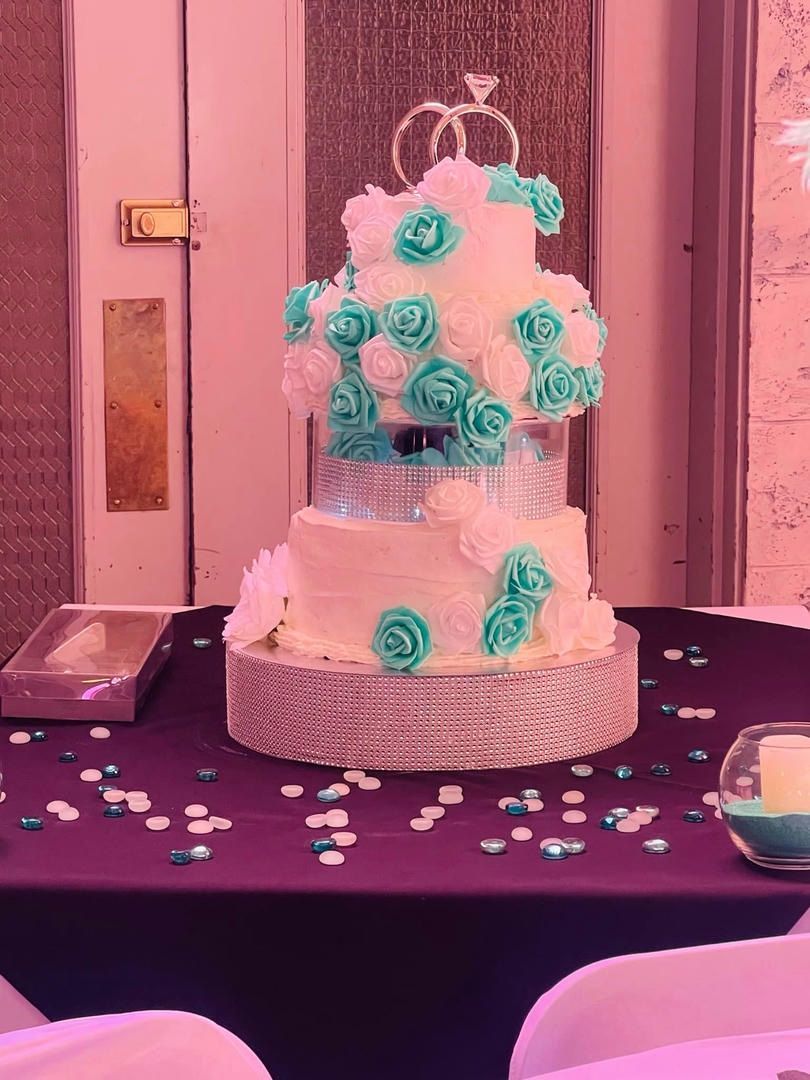 A wedding cake on a table with a purple table cloth