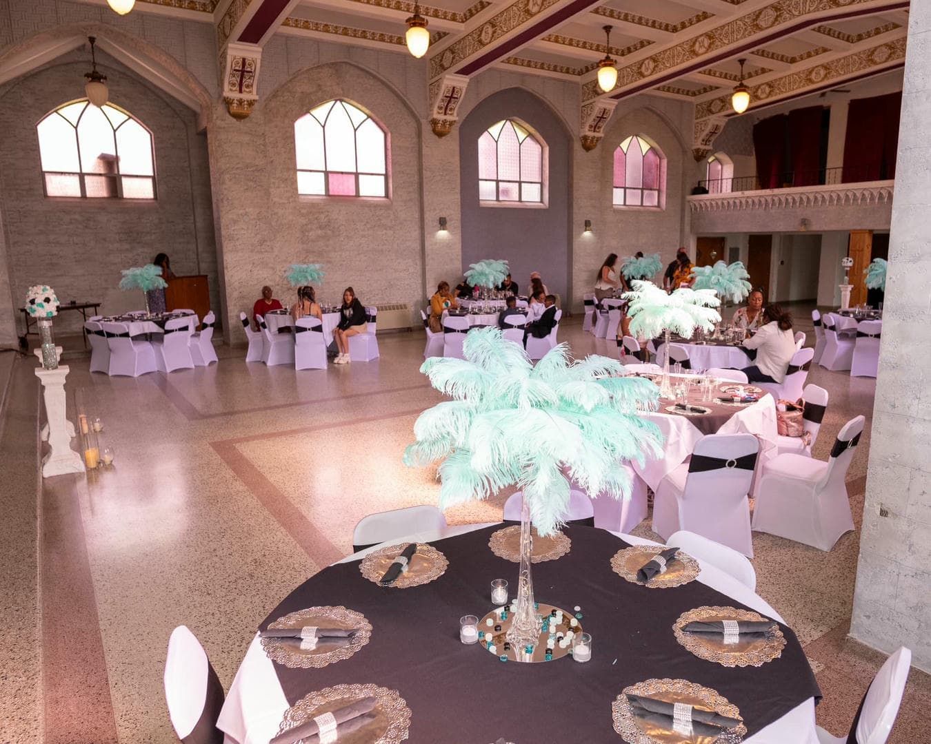 A large room with tables and chairs set up for a wedding reception