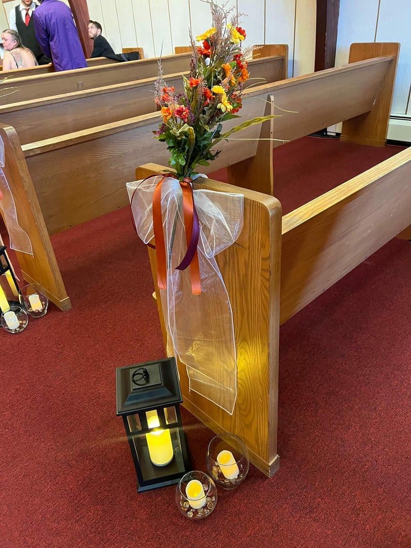 A church with a lantern and flowers on the benches