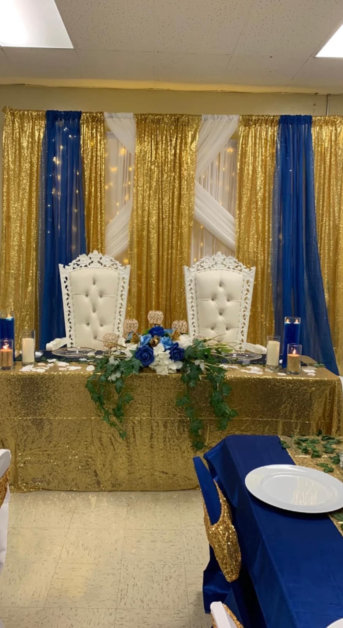 A couple of chairs sitting at a table in front of a gold and blue backdrop.
