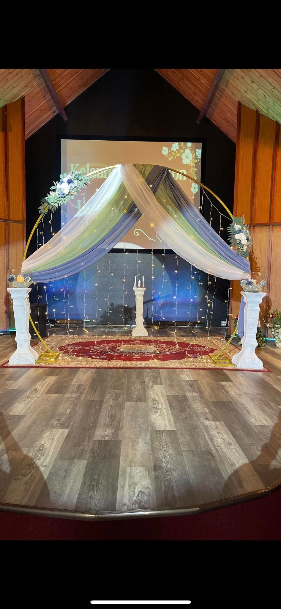There is a stage in the middle of the room with a canopy over it.