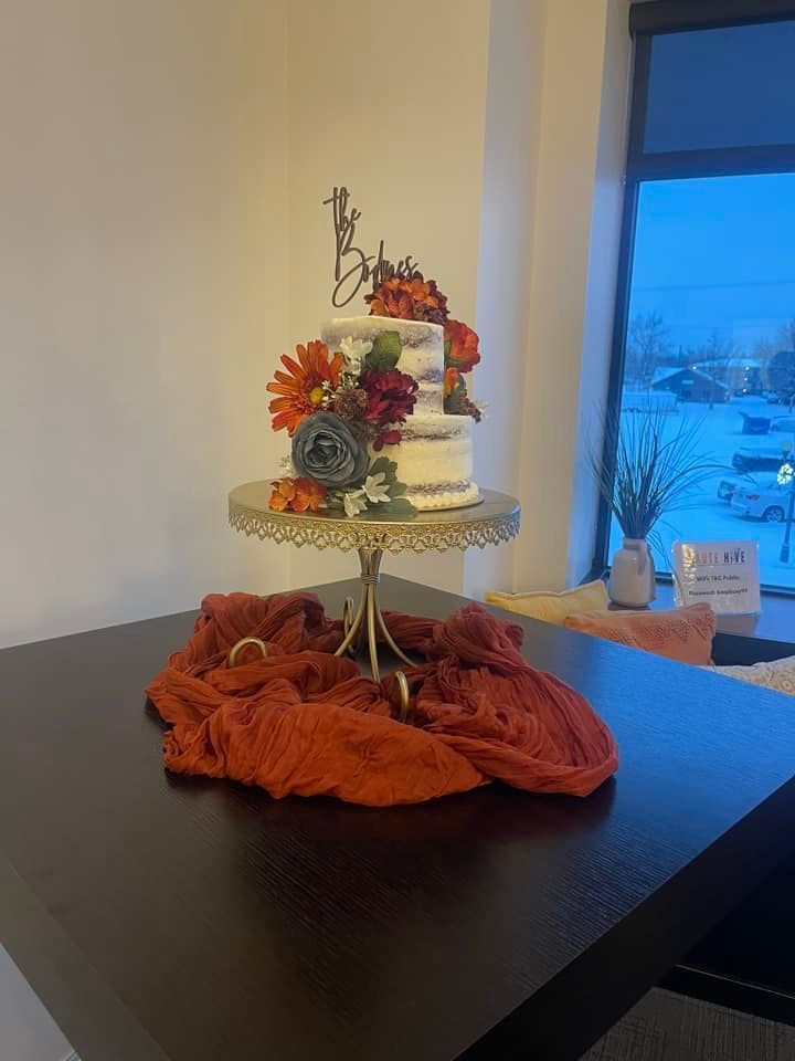 A wedding cake is sitting on top of a cake stand on a table.