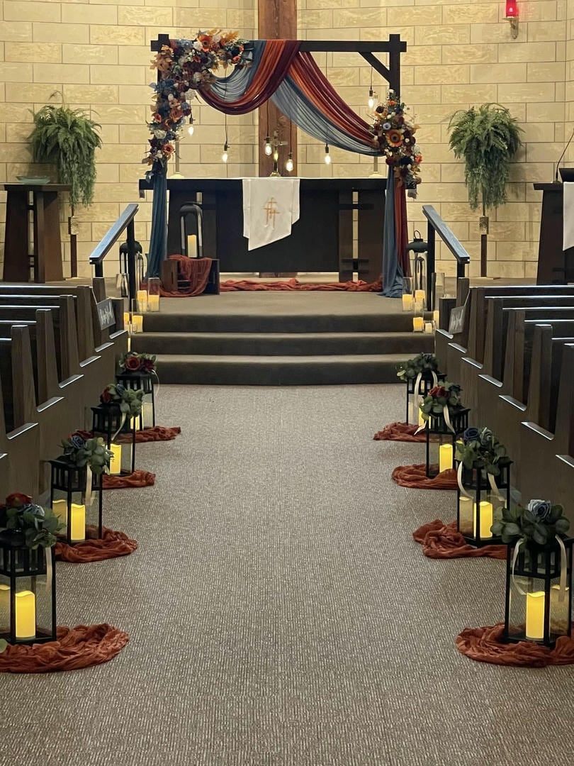 A church is decorated with lanterns and flowers for a wedding ceremony