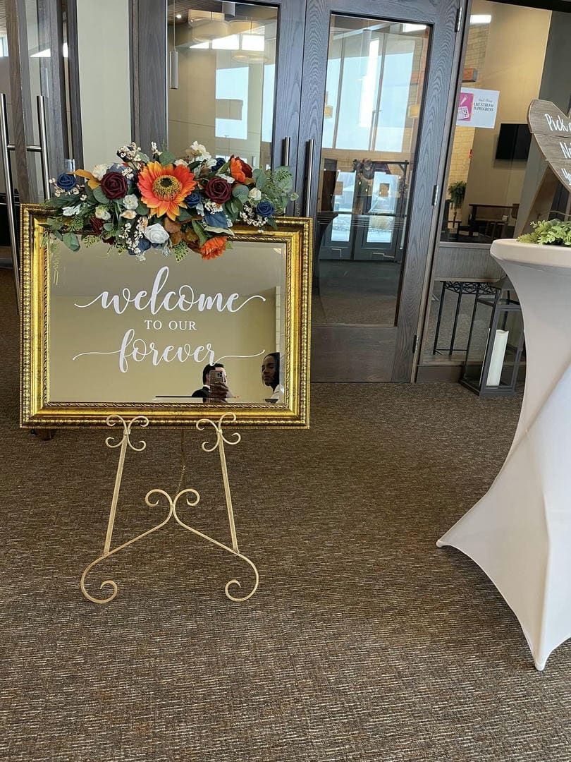 A welcome to our forever sign is sitting on a easel in front of a door.