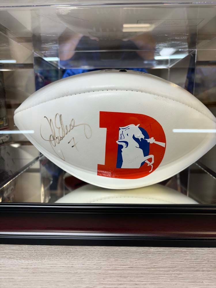 A signed football is sitting in a glass case.