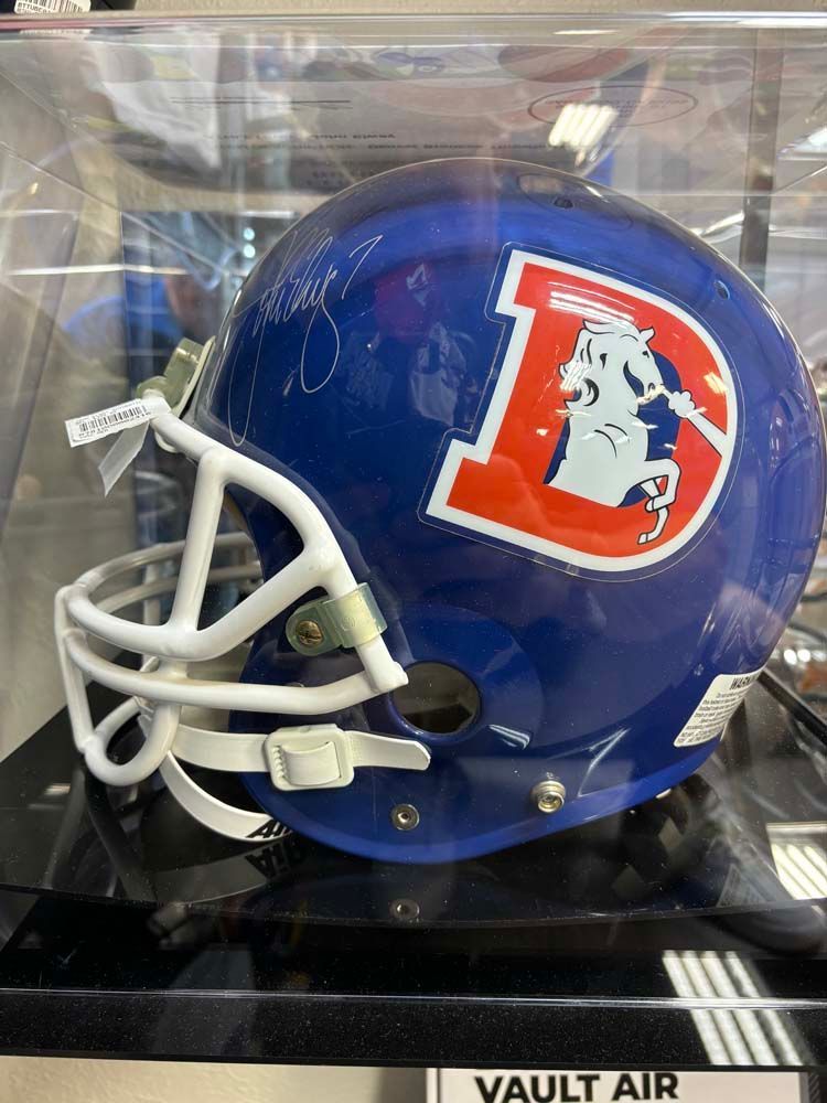 A blue football helmet is displayed in a clear case.