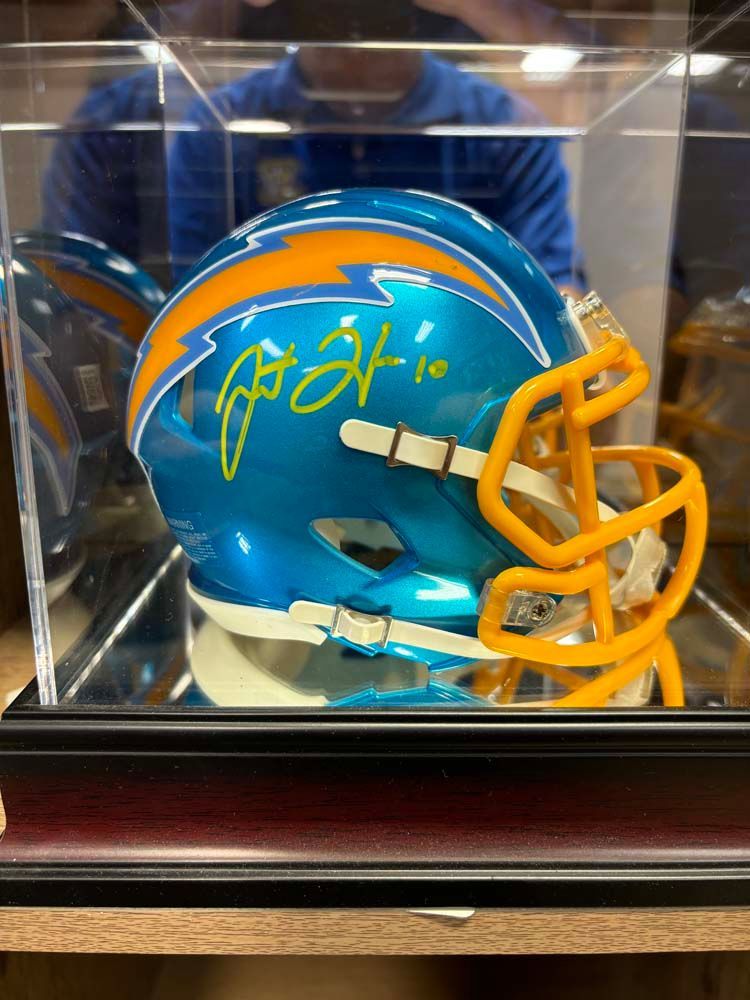 A blue and yellow football helmet in a display case