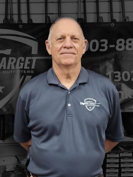 A man standing in front of a target outfitters sign