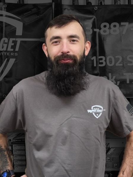 A man with a beard is wearing a grey shirt