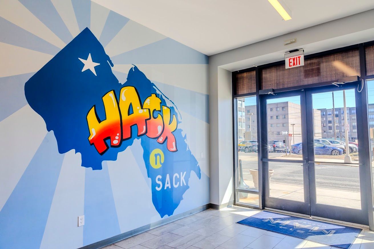 A room with a mural on the wall that says hack sack