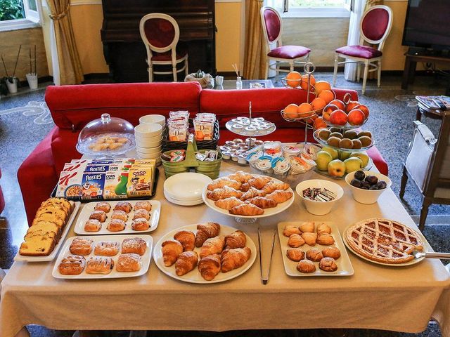 Colazione servita su un tavolo in una stanza con divano. Include dolci, frutta e cibi confezionati.