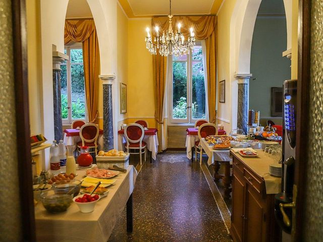 Sala colazioni con buffet e tavoli. Finestre con tende, lampadario, pavimenti in marmo.