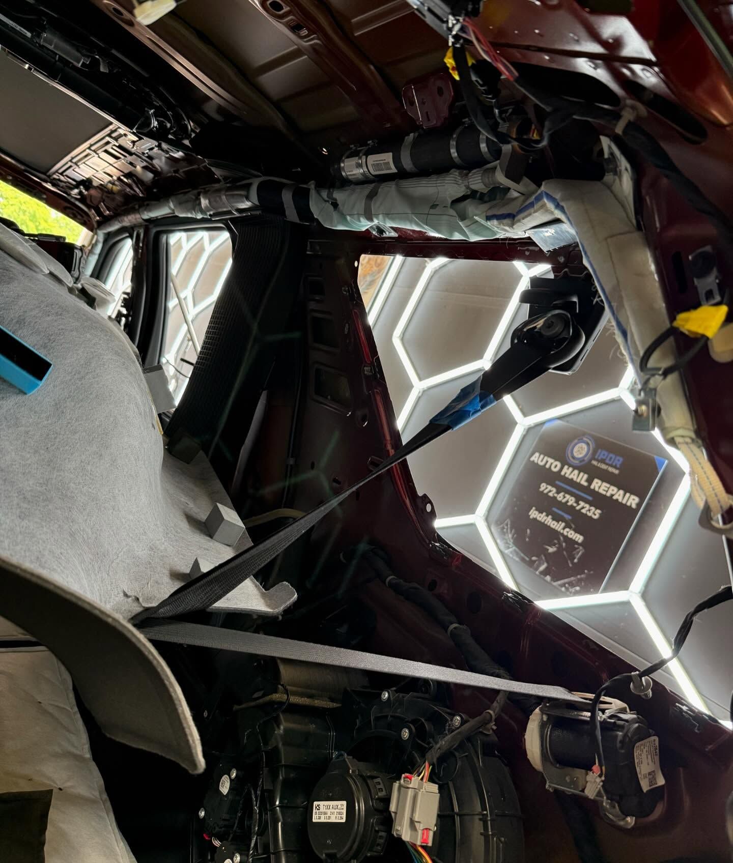 Interior car frame with wiring and air bag components visible during auto body repair.
