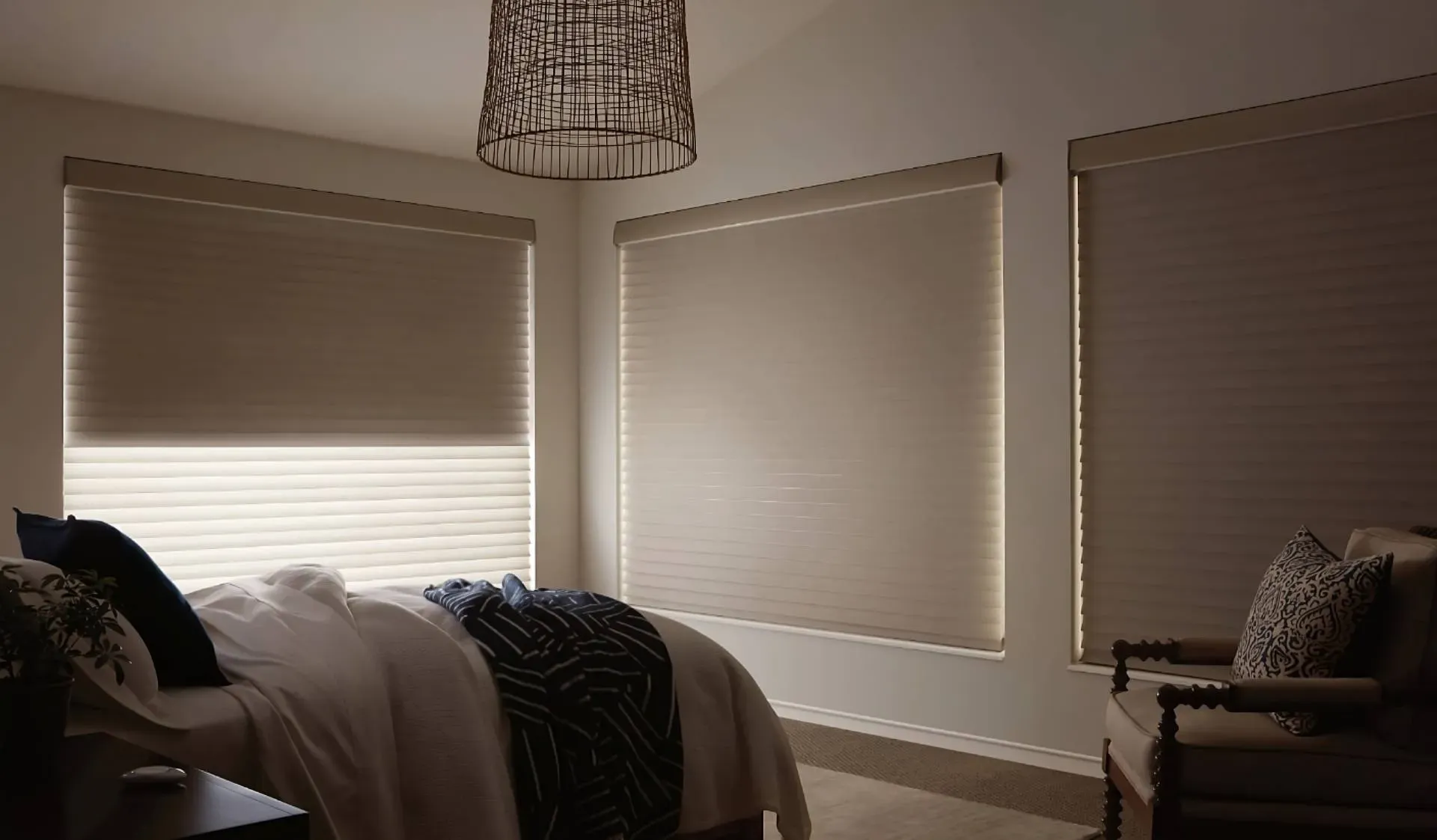 Automatic shades on three bedroom windows with the PowerView® Pebble® Remote on the nightstand near Seattle, WA