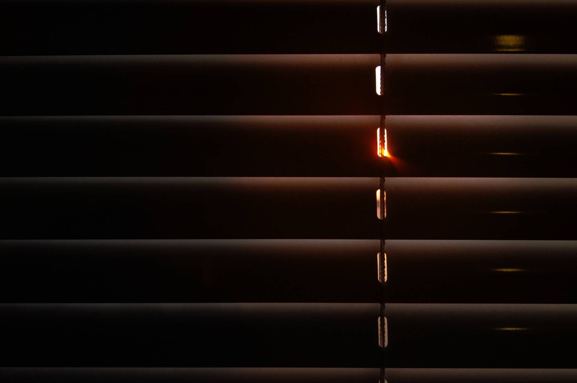Light gaps peaking through the slats of window blinds in a home near Seattle, WA