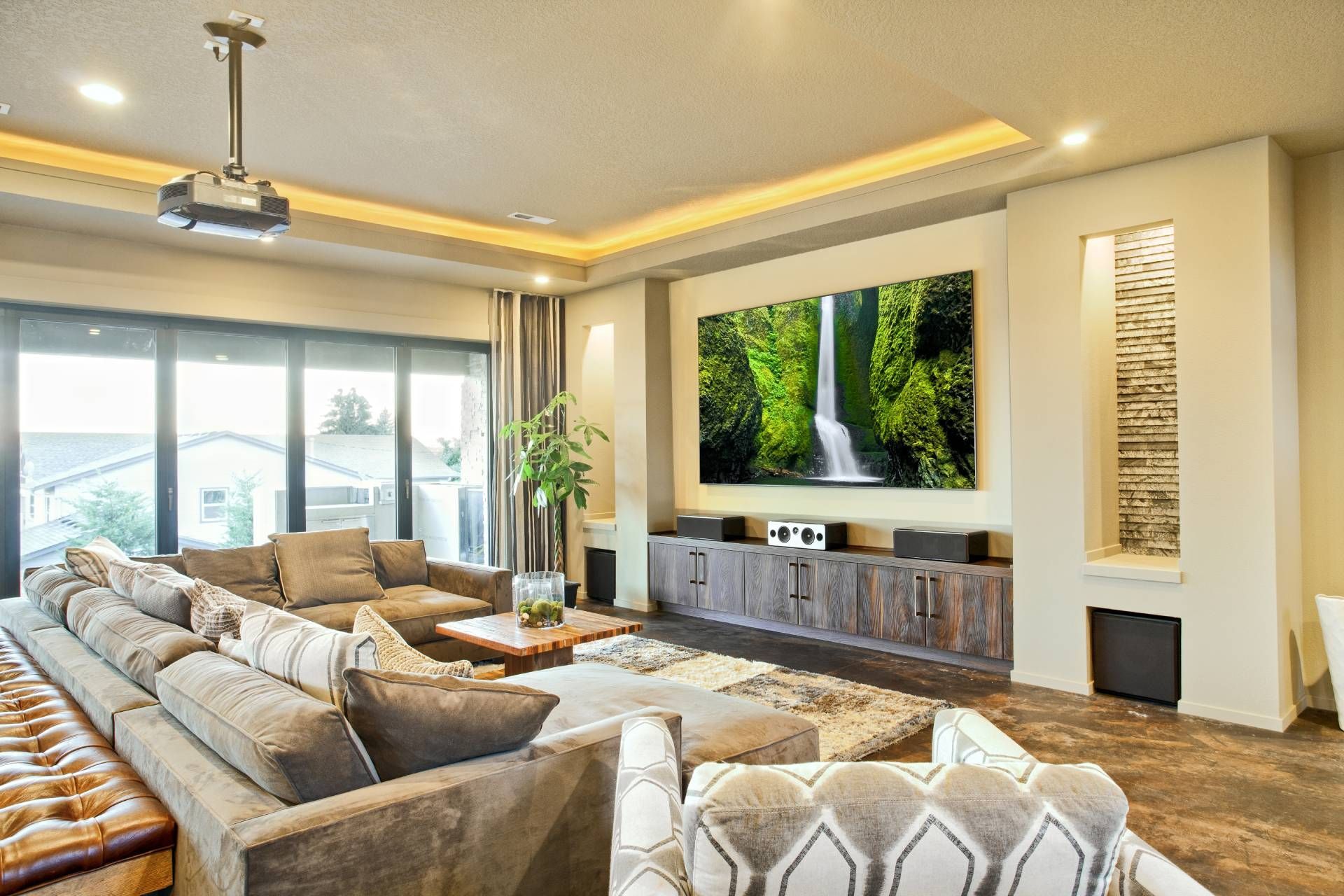 Home theater with a projector on the ceiling and custom drapes drawn open at the window