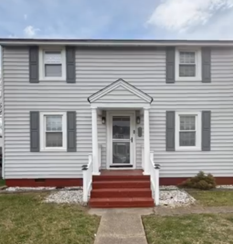 Gray two-story house with red steps, white trim, and a front porch entrance