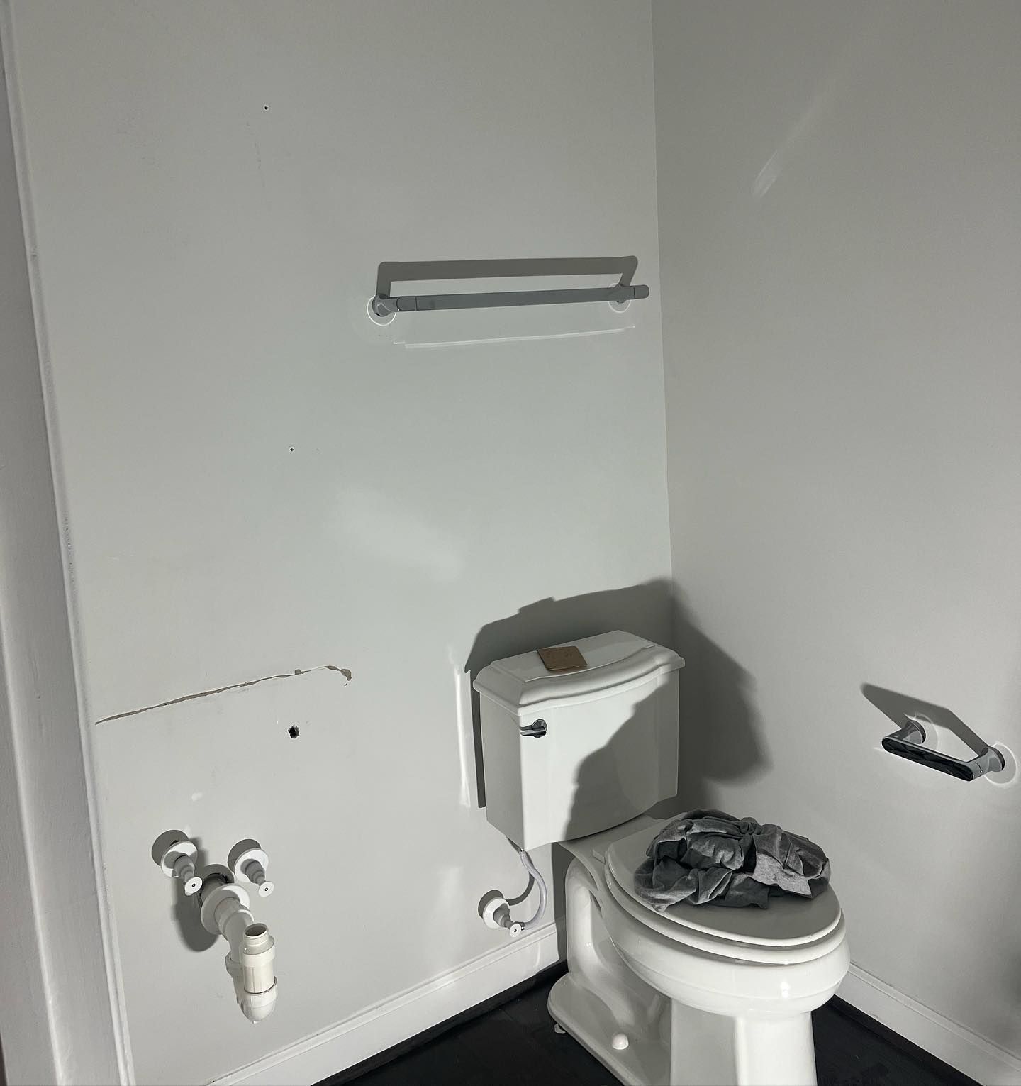 A bathroom with a toilet and a towel rack on the wall.