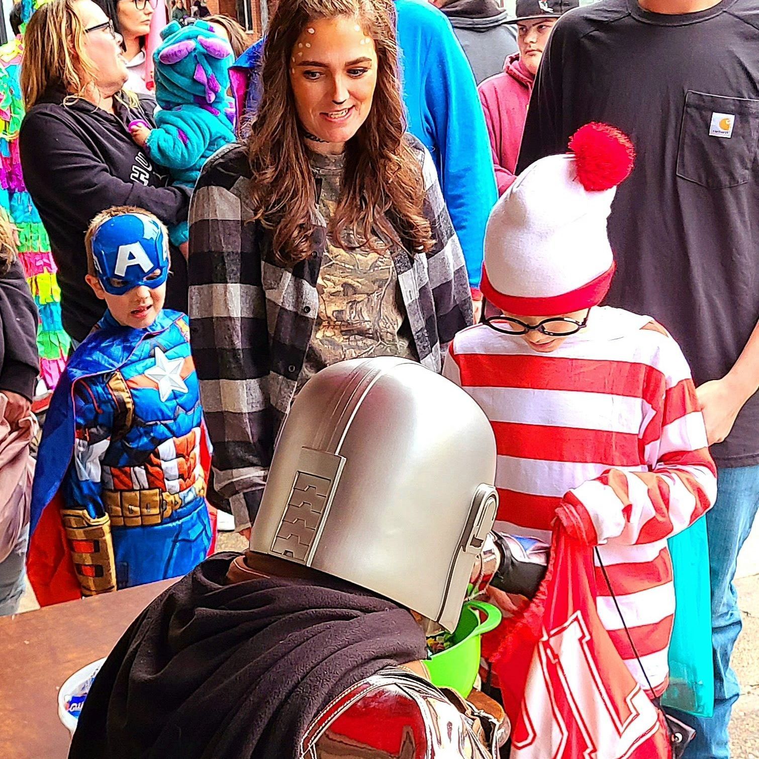 A man and a woman are smiling in front of a christmas present.