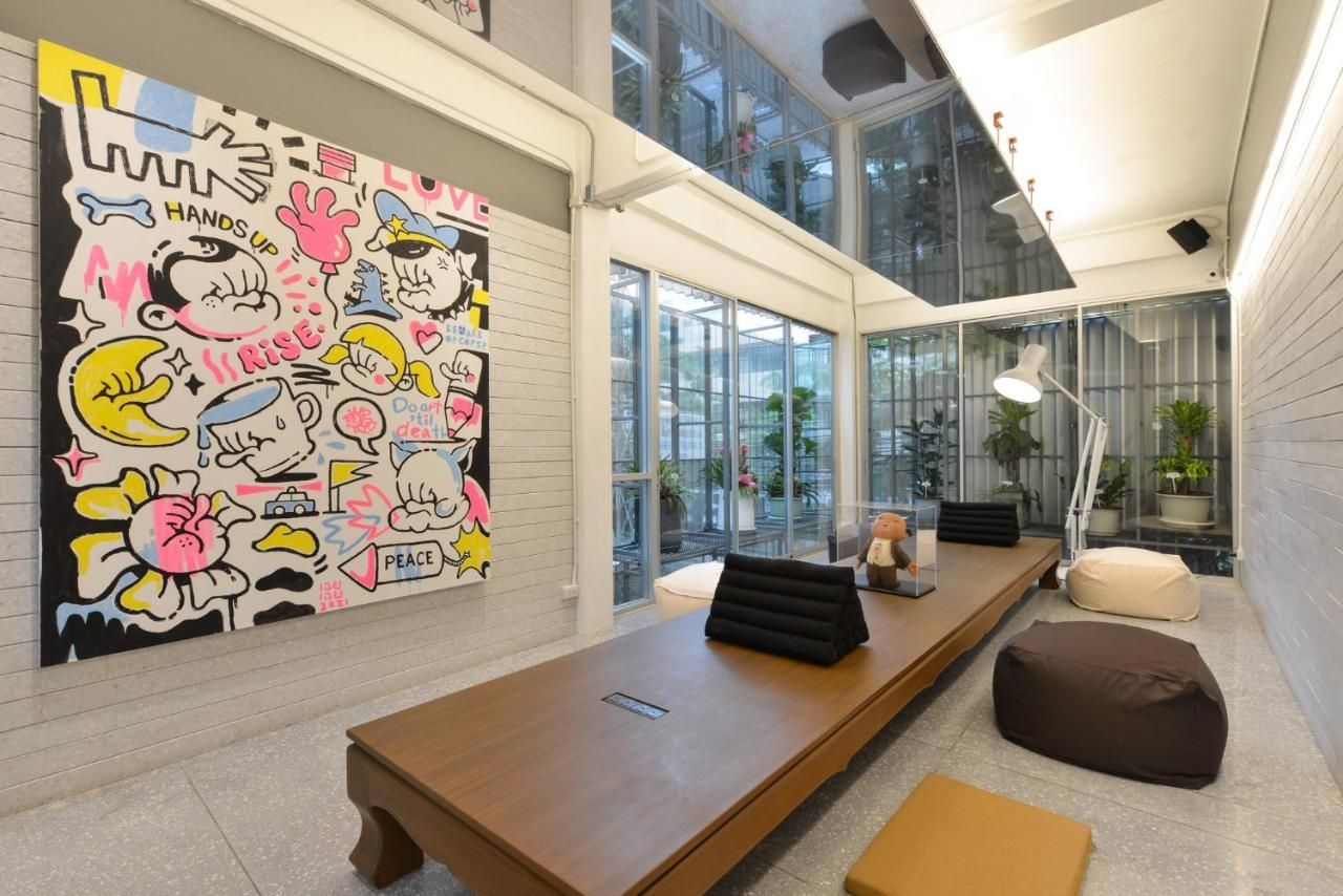 A room with a long table and a large painting on the wall.