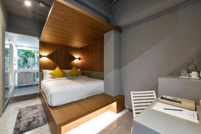 A hotel room with a king size bed and a desk.