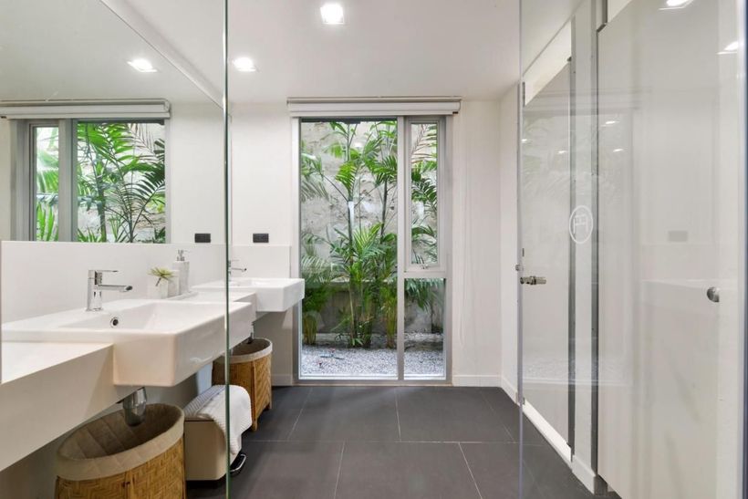 A bathroom with two sinks and a walk in shower.