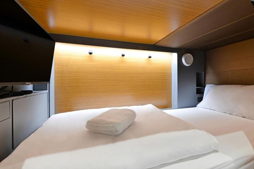 A hotel room with a bed and a television