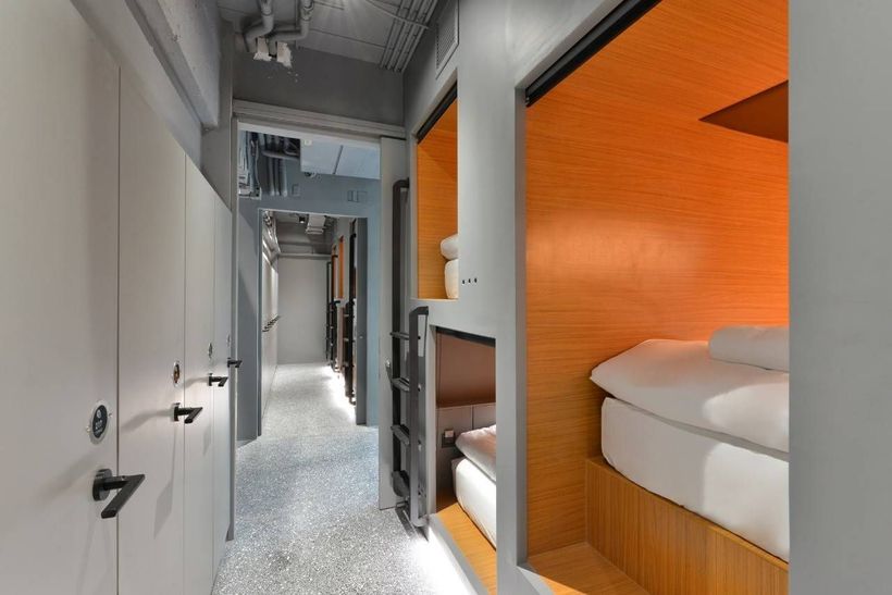 A hallway with a row of bunk beds in a hotel room.