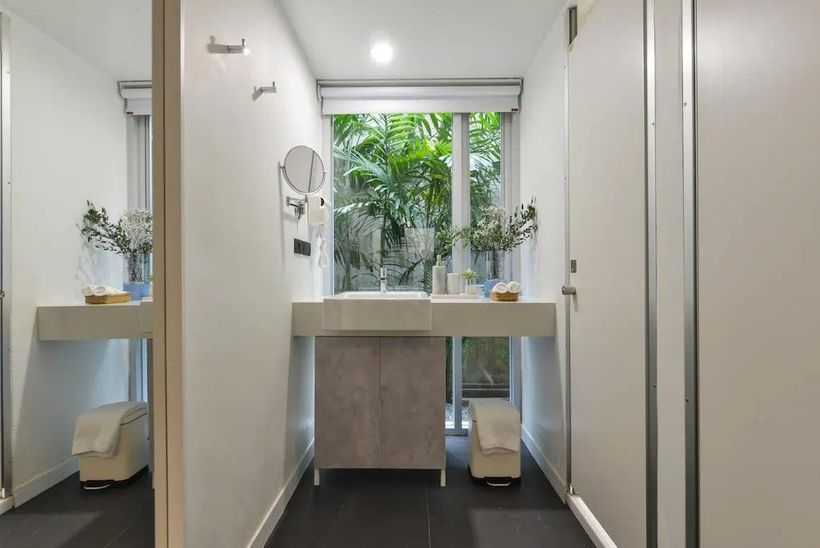A bathroom with a sink , mirror , and window.