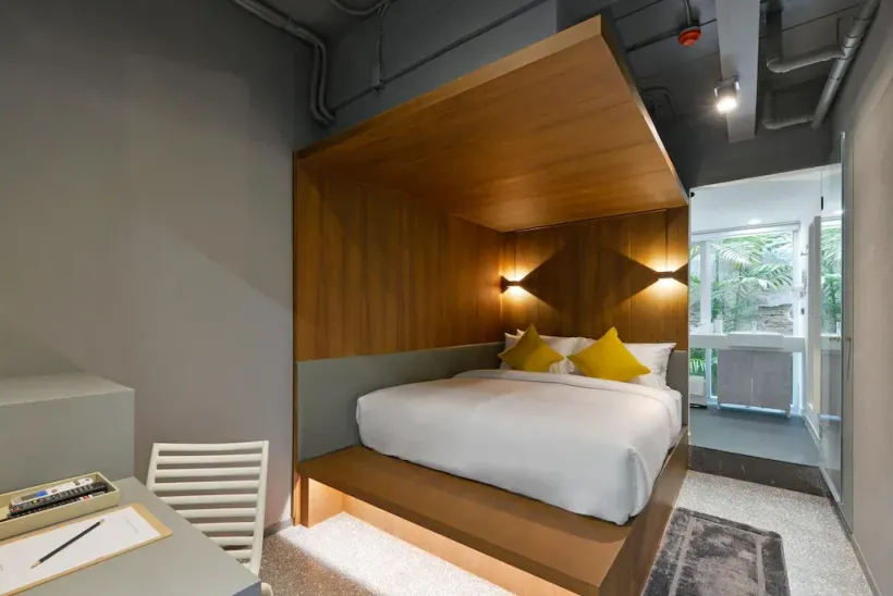 A bedroom with a bed and a desk in it.