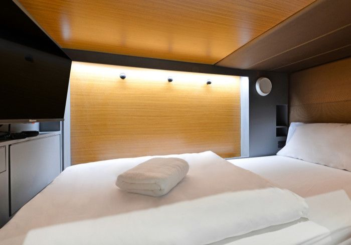 A hotel room with a bed and a towel on the bed