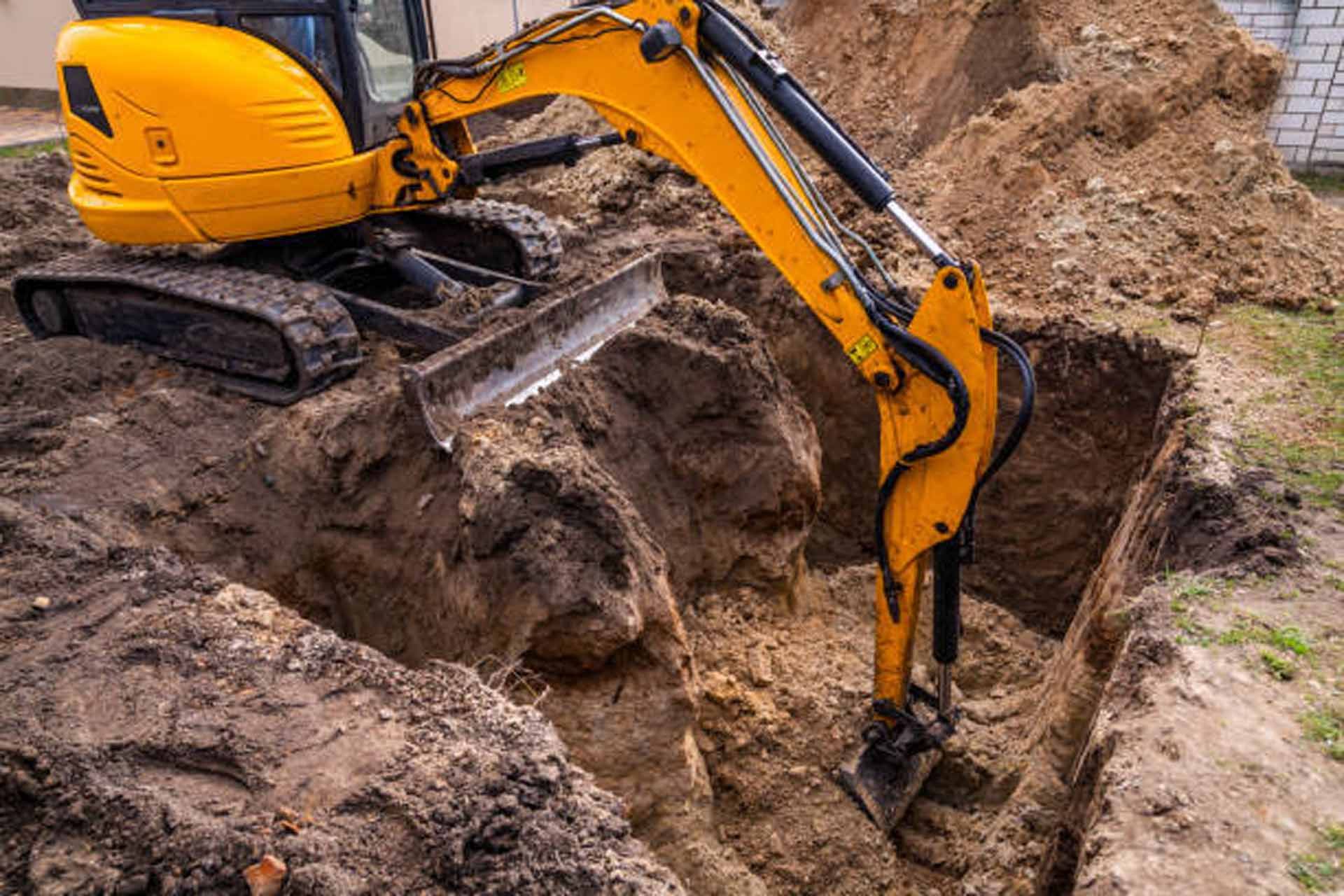 Concrete cylinder in a hole in the ground, likely a well or access point for underground utilities.