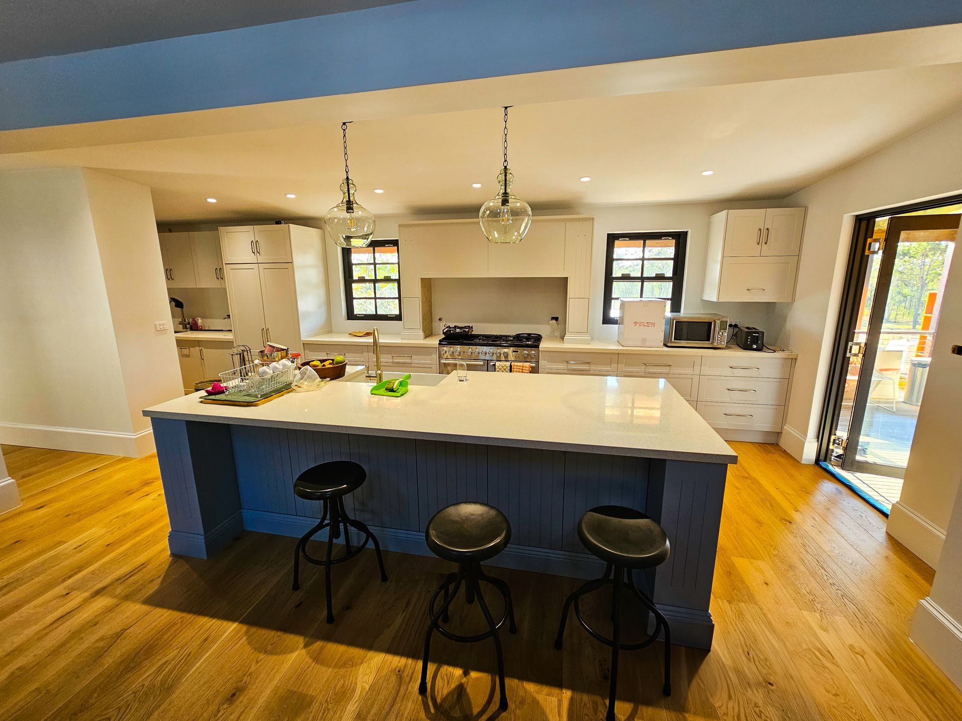 An empty kitchen with white cabinets and a large island