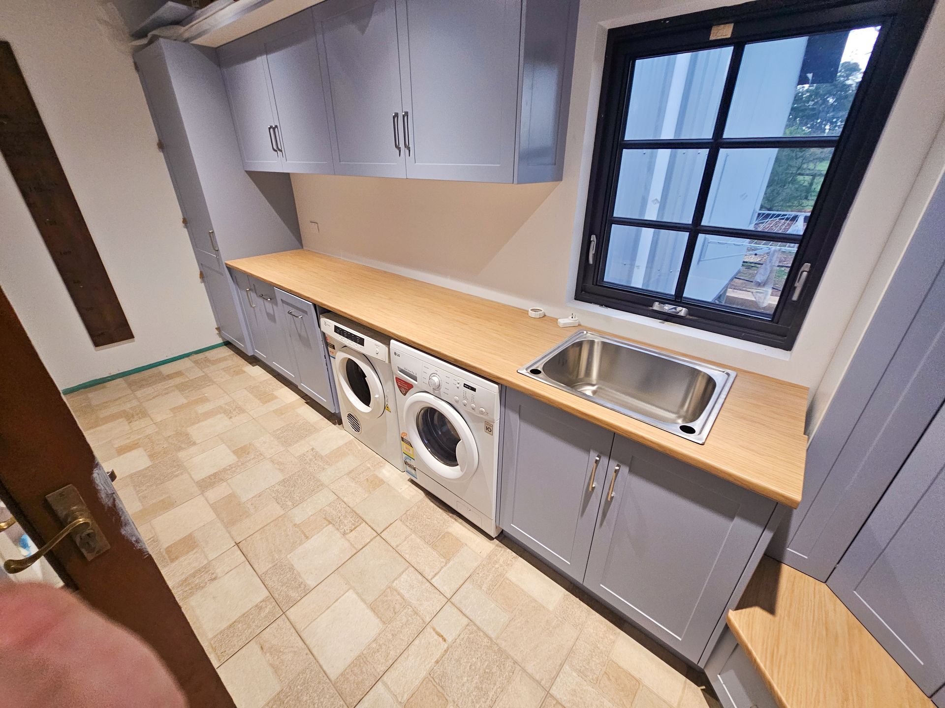 A kitchen with white cabinets , stools , a stove and a large island.