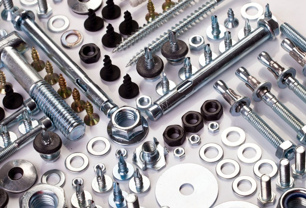 Various metal screws, nuts, washers, and bolts arranged on a light surface — CQR Locksmiths In Moree, NSW