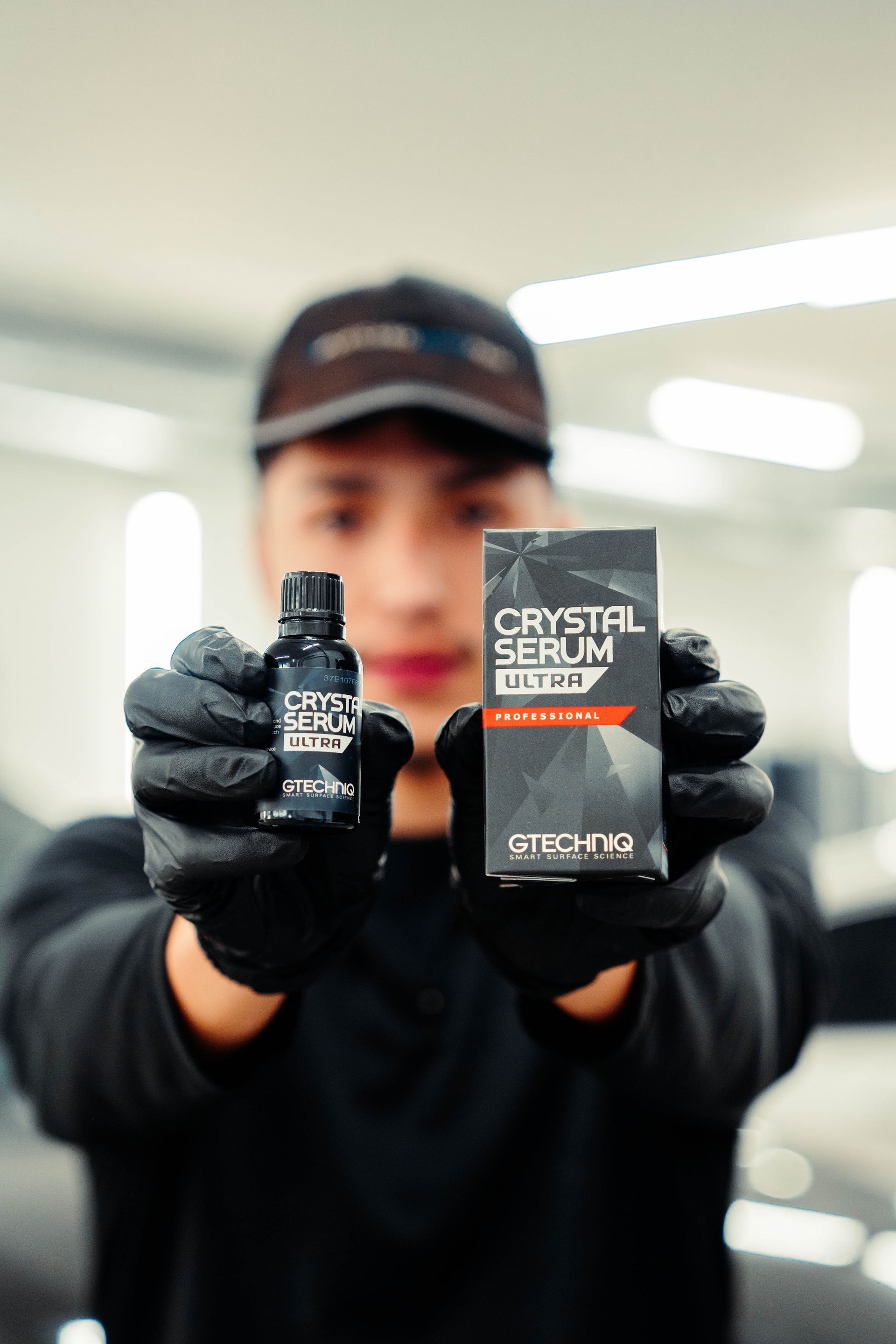 Person holding a black deodorant bottle and box labeled 