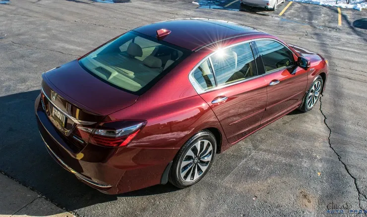 A red honda accord is parked in a parking lot.