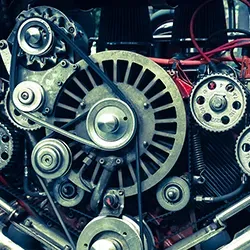 Close-up of engine with belts, pulleys, and gears, illustrating mechanical components and their intricate design.