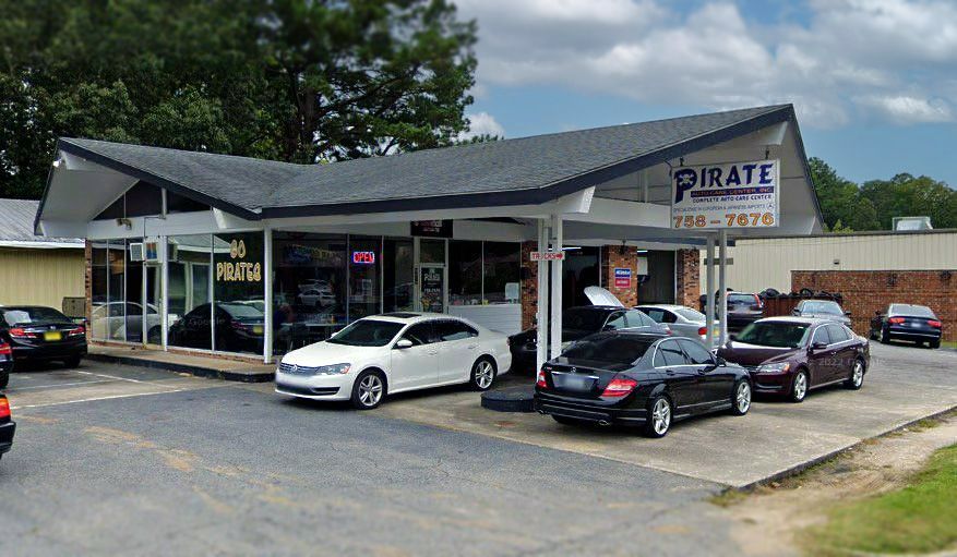A car dealership with cars parked in front of it.